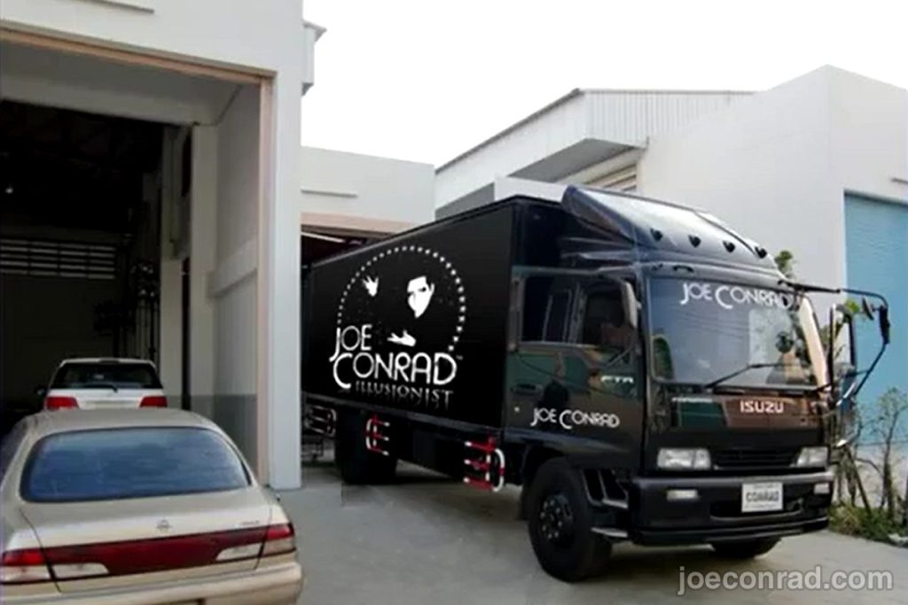 Joe Conrad Illusionist branded delivery truck outside warehouse